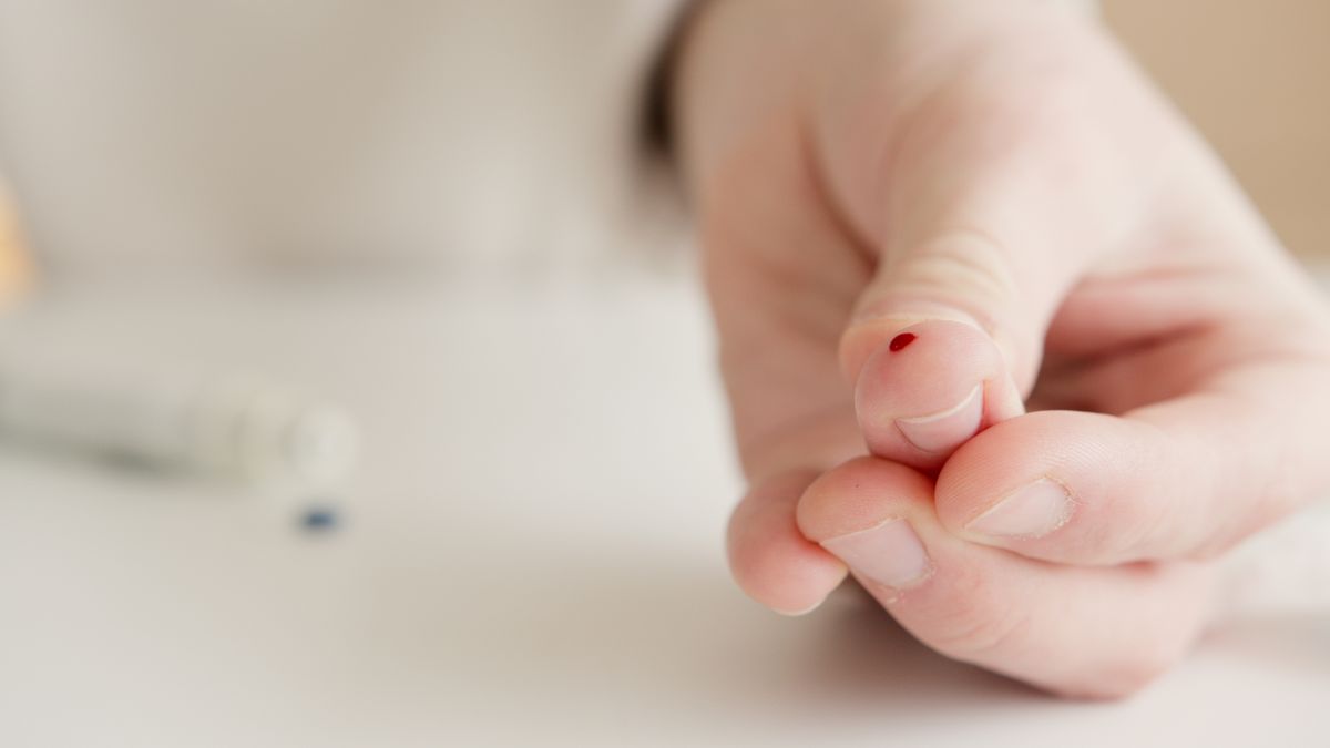 Ponta do dedo com uma gota de sangue depois do teste de glicemia capilar