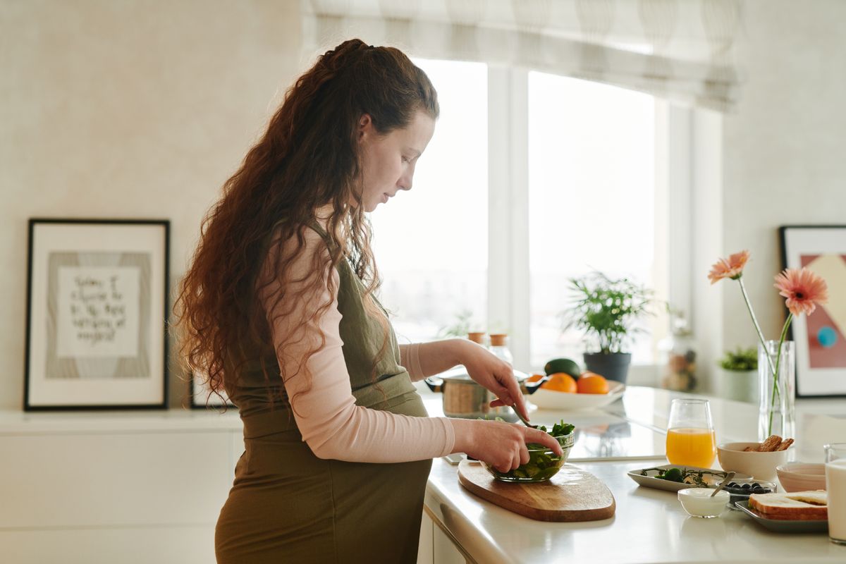 Gestante preparando uma salada na cozinha