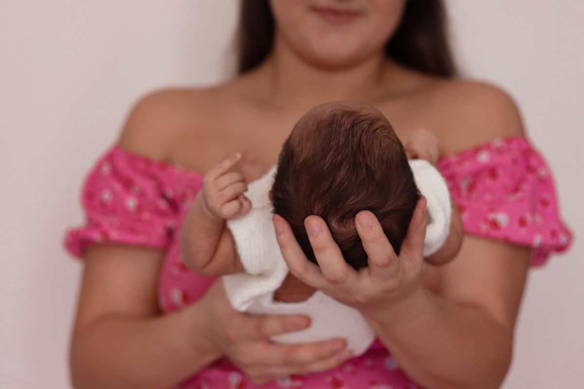 Mãe com o recém-nascido no colo